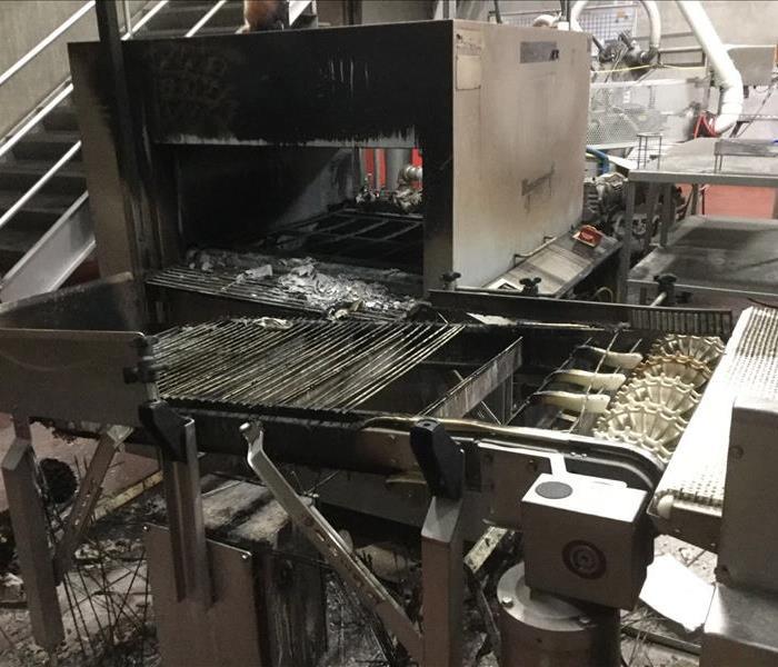 Smoke and soot covered machinery. Twisted pices of metal as a result of an electrical fire